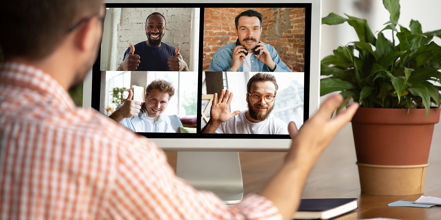 Remote meeting. Man working from home during coronavirus or COVID-19 quarantine, remote office concept. Young businessman, manager in front of monitor during online conference with colleagues and team.